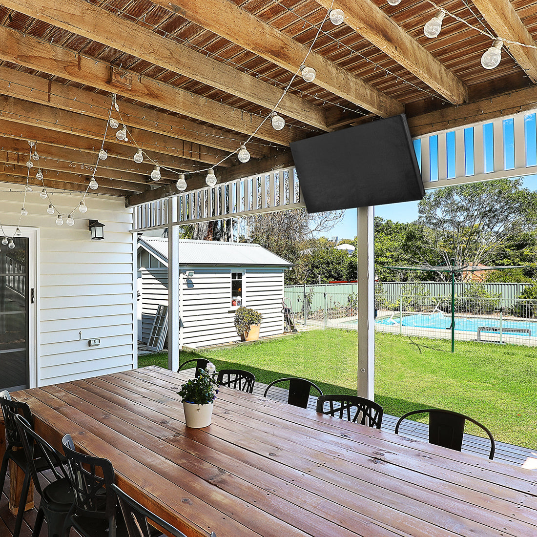 Protective flat screen TV cover in an outdoor patio area.