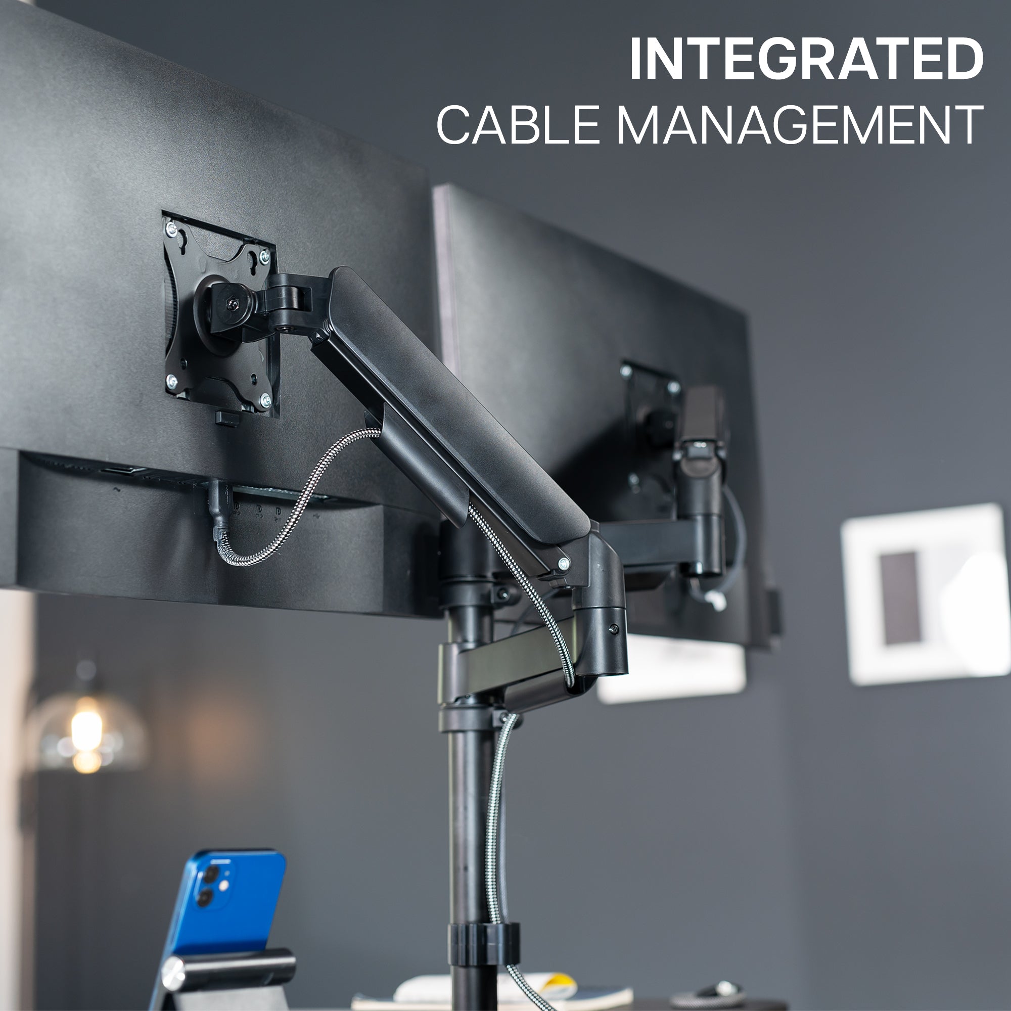 Height adjustable desk riser with articulating mechanical dual monitor mount.