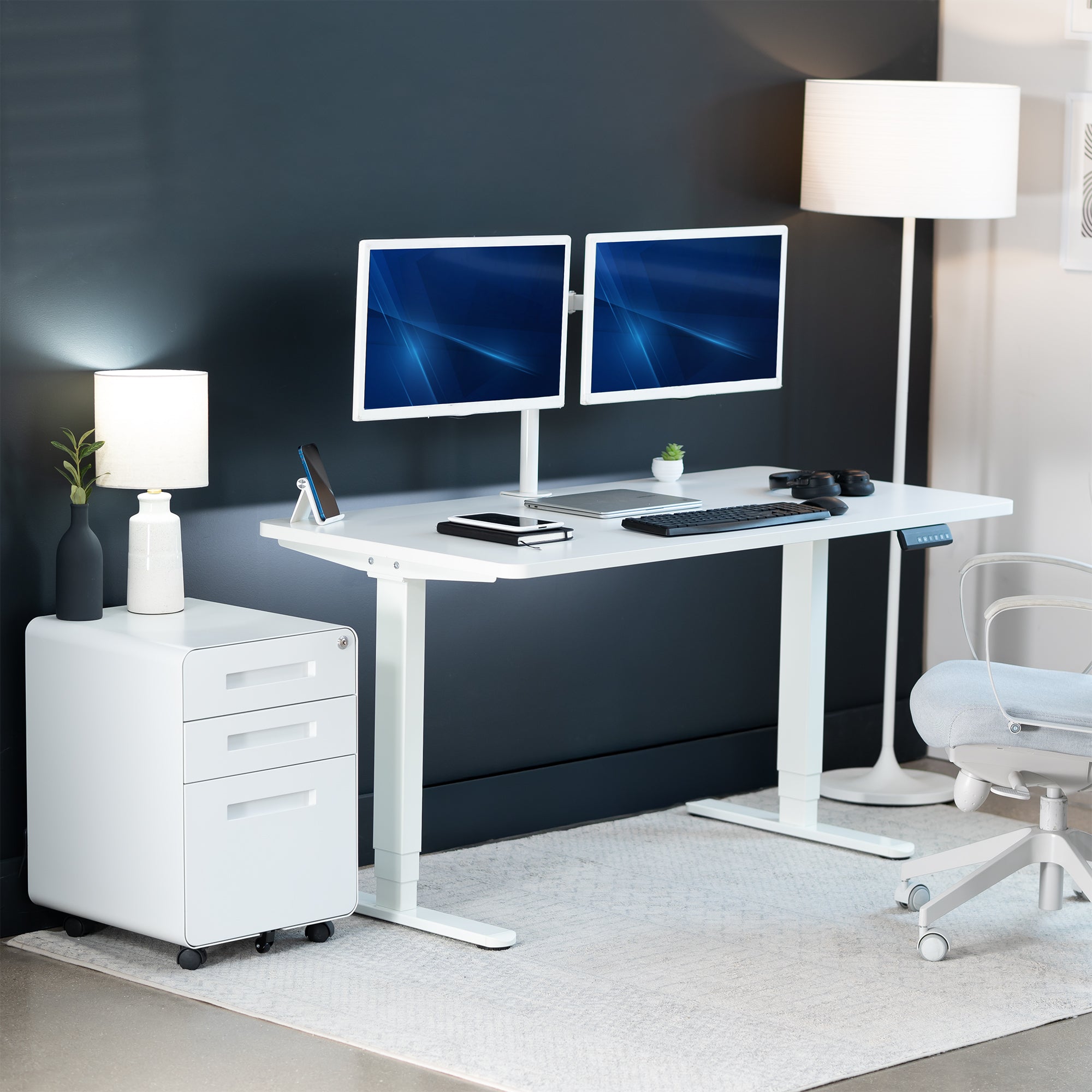 Modern office setup with a white desk, two monitors, and office furniture.