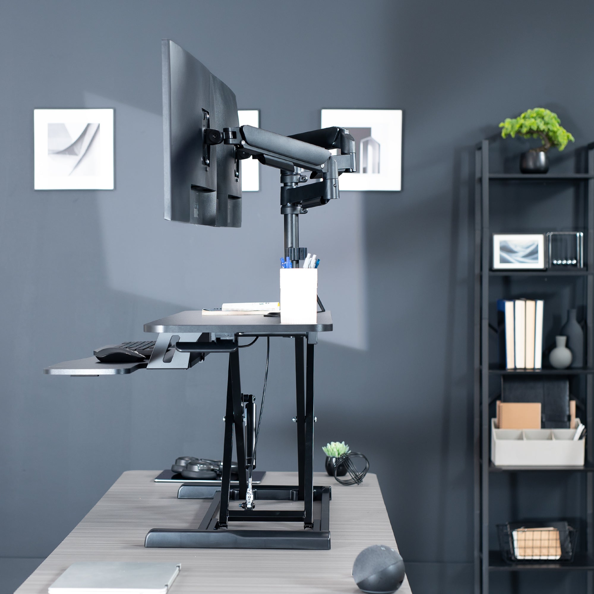 42 inch height adjustable desk riser with articulating mechanical dual monitor mount.