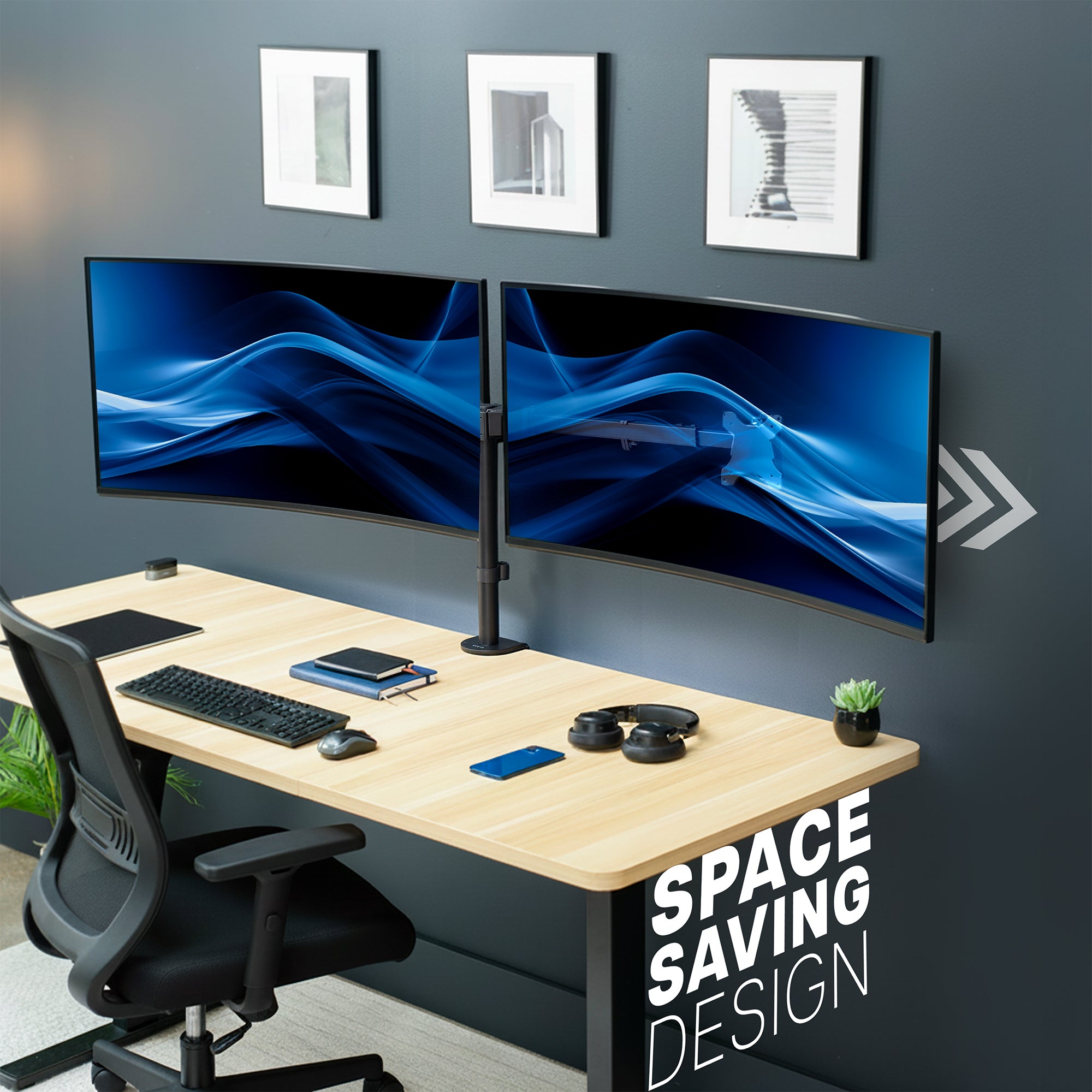 Modern office desk setup with dual monitors on telescoping arm monitor mount, desk accessories, a chair, and decor on a gray wall.