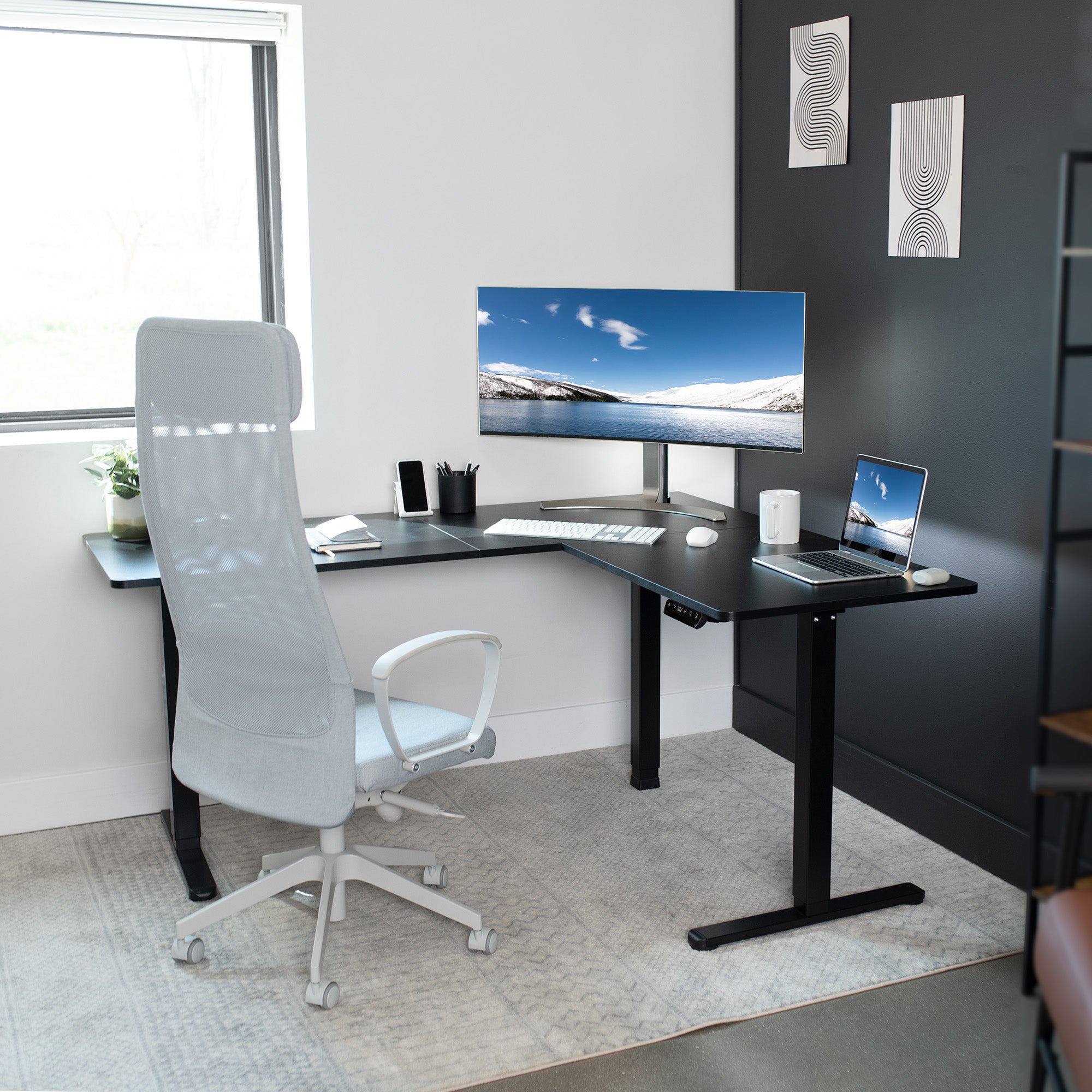 Modern office workspace with sit-to-stand electric desk.