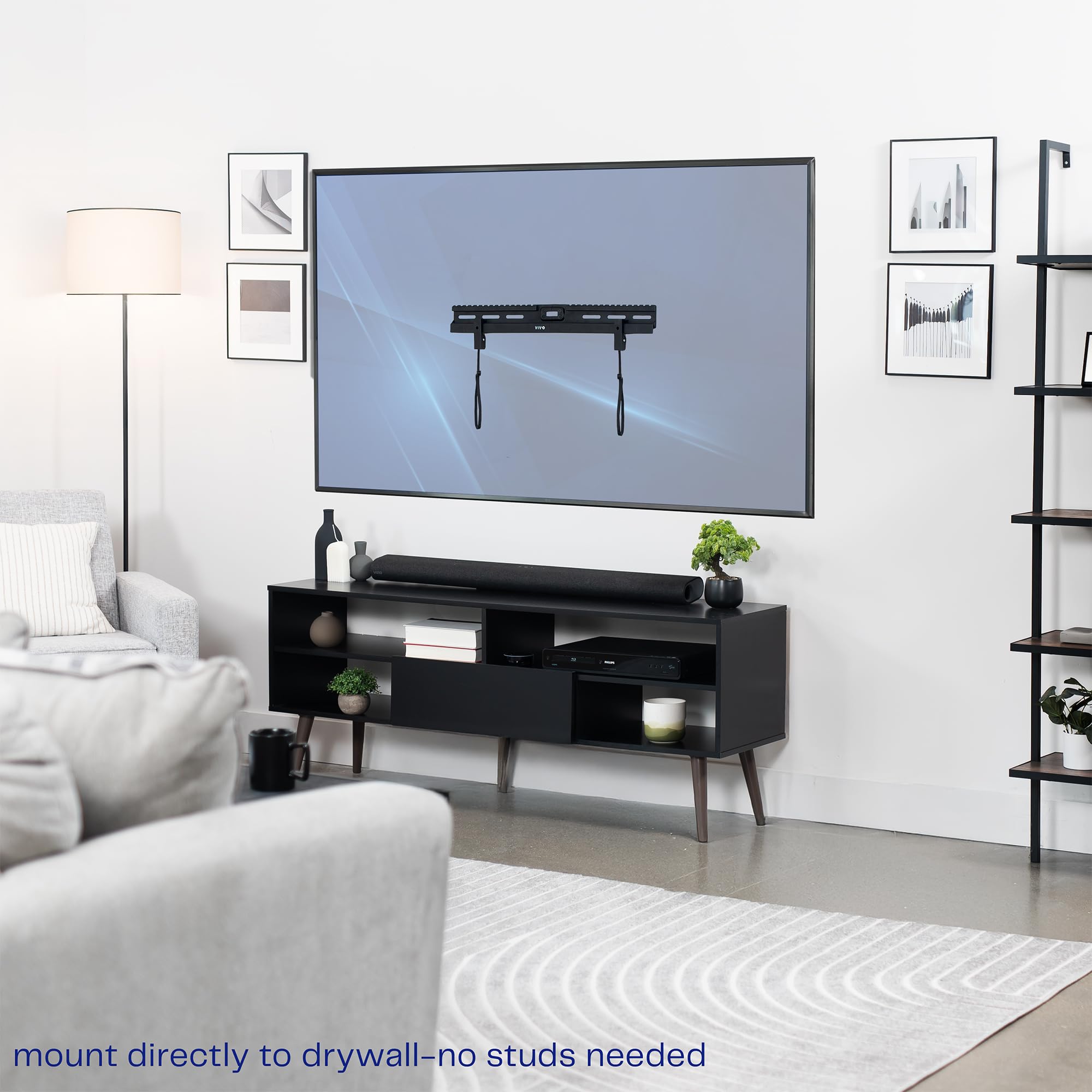 Living room with a TV mounted on the wall above a black entertainment console.