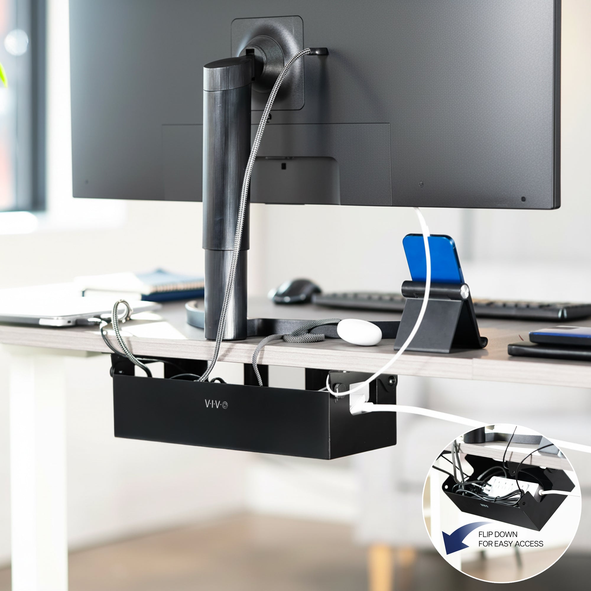 Desk setup with a monitor, keyboard, mouse, and cable management system with a flip down feature providing easy access.