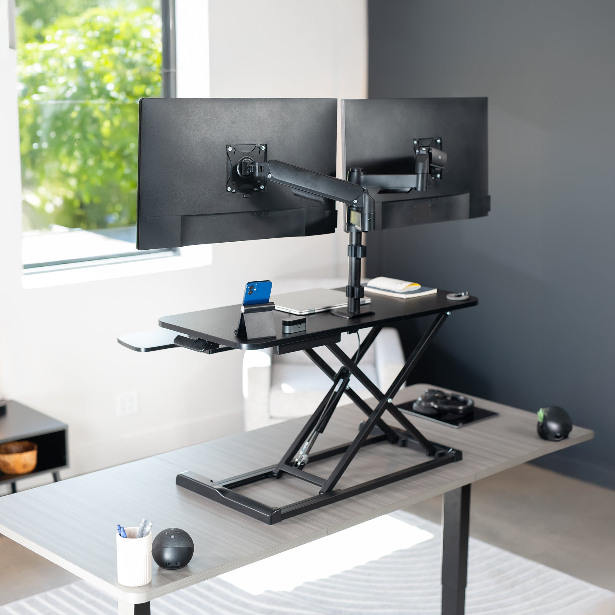 36 inch height adjustable desk riser with articulating mechanical dual monitor mount.
