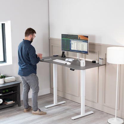 Sit to stand height adjustable electric desk with push button memory controller for ergonomic office workstation.
