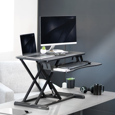 Sturdy height adjustable 2-tiered desk riser for ergonomic office workstation in  office setting. 