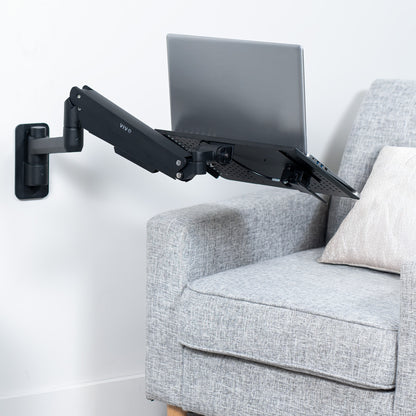 Pneumatic Wall Mounted Laptop Tray on wall creating a floating workspace.