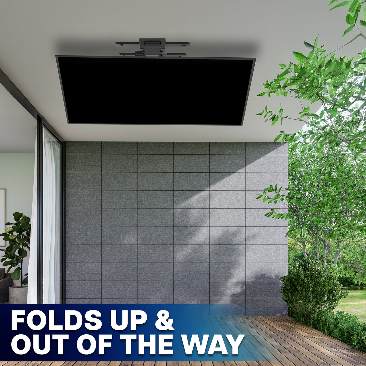 A TV mounted on a ceiling, shown folded down in an outdoor patio setting with a tiled wall, wooden deck, and green trees. A blue banner at the bottom reads 'FOLDS UP & OUT OF THE WAY'.