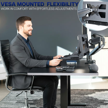 Man sitting at a desk with the VIVO Wall and VESA Flip Down Mount attached to a monitor arm holding a laptop at the desk