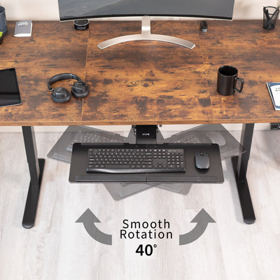 Wooden desk with a keyboard tray, monitor, and office items on a light wood floor.