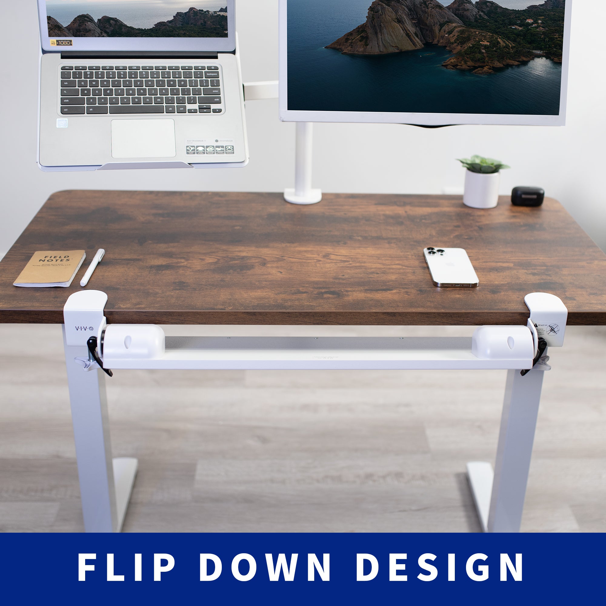 Wooden desk with a laptop, monitor, phone, and notebook on a light wood floor.