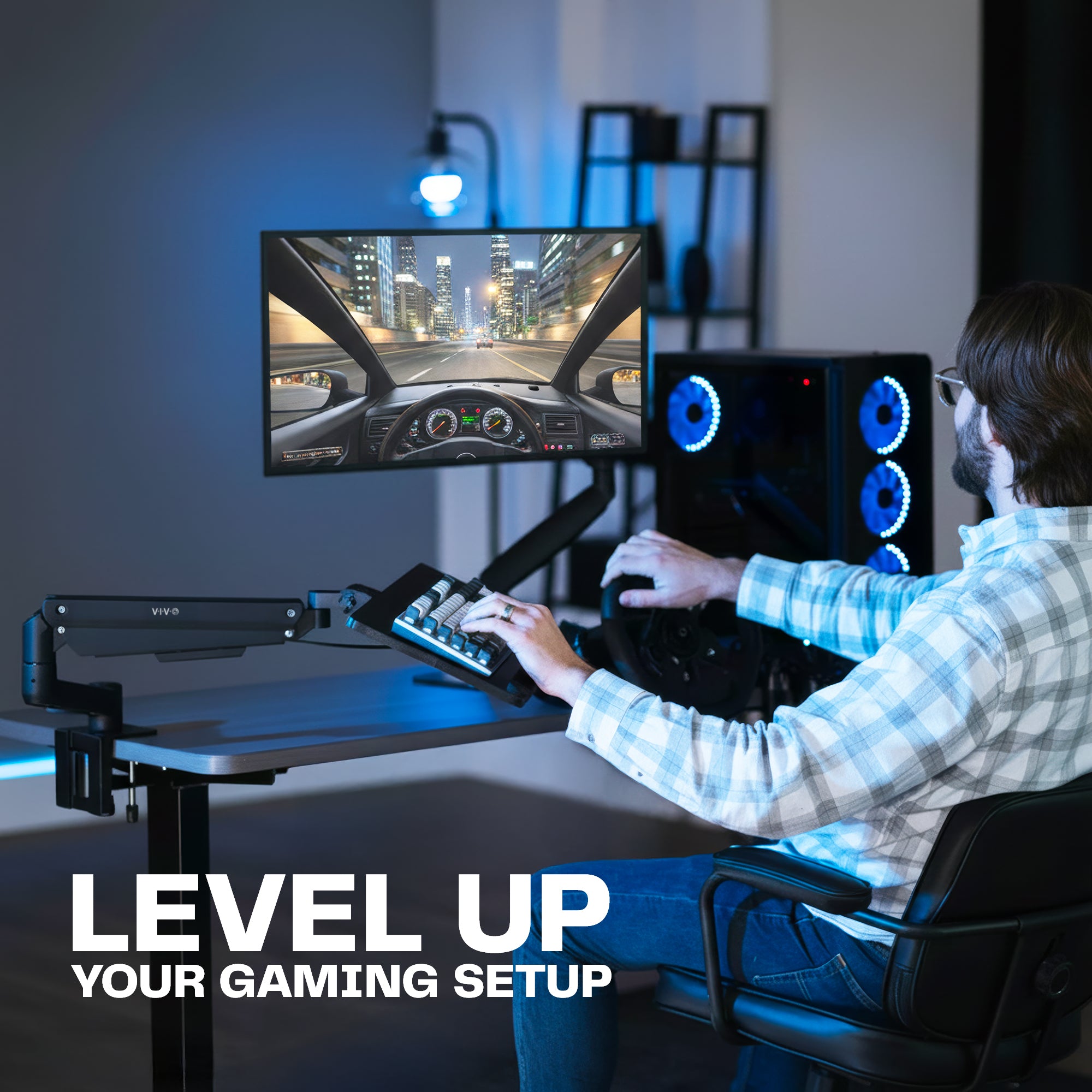 Person playing a racing game on a computer setup with a monitor on a desk mount and a keyboard tray clamped onto their desk, seated in a gaming chair creating the ultimate gaming setup.