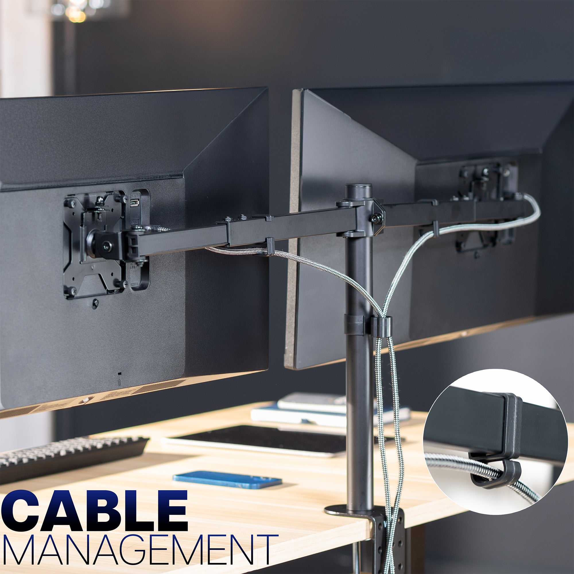 Desk setup with dual monitor mounts and cable management system on a desk.