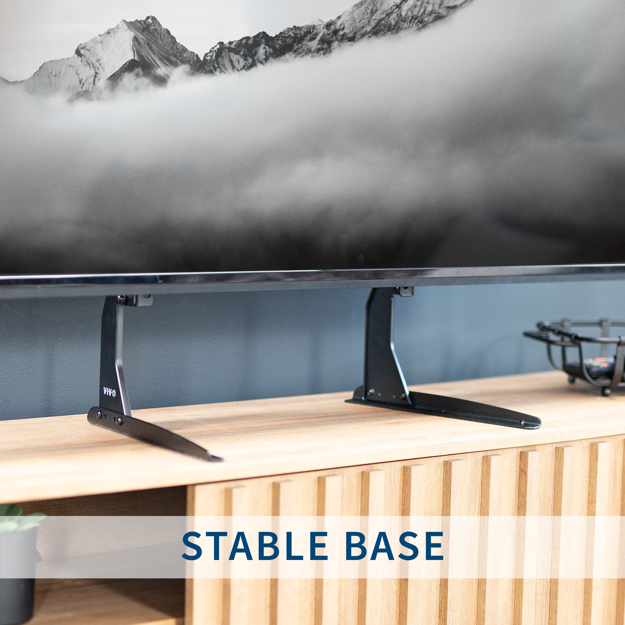 TV on a stable base with a mountainous landscape in the background