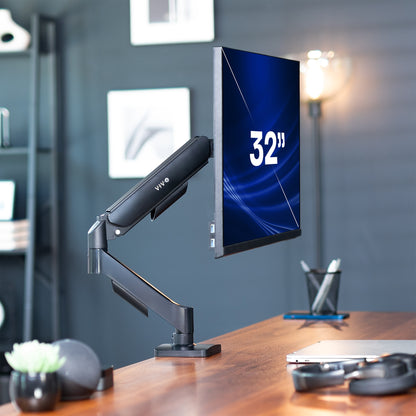 32-inch monitor on a Mechanical Arm Single 17" to 32" Monitor Desk Mount on a desk with a blurred office background