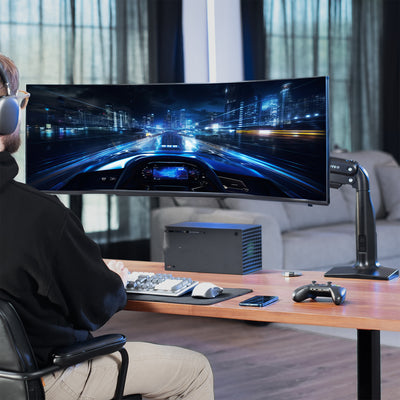 Person playing a racing game on a large monitor in a modern living room.