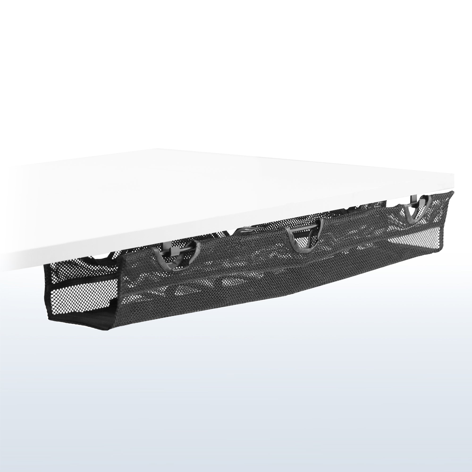 A black mesh cable management system with a power strip holder underneath a white desk.