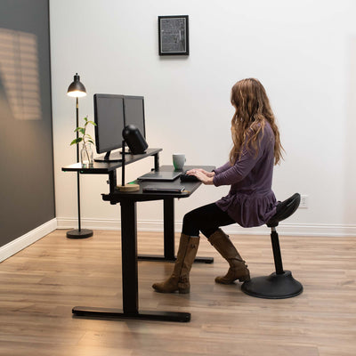 Girl working and typing at an electric split-top desk from VIVO.
