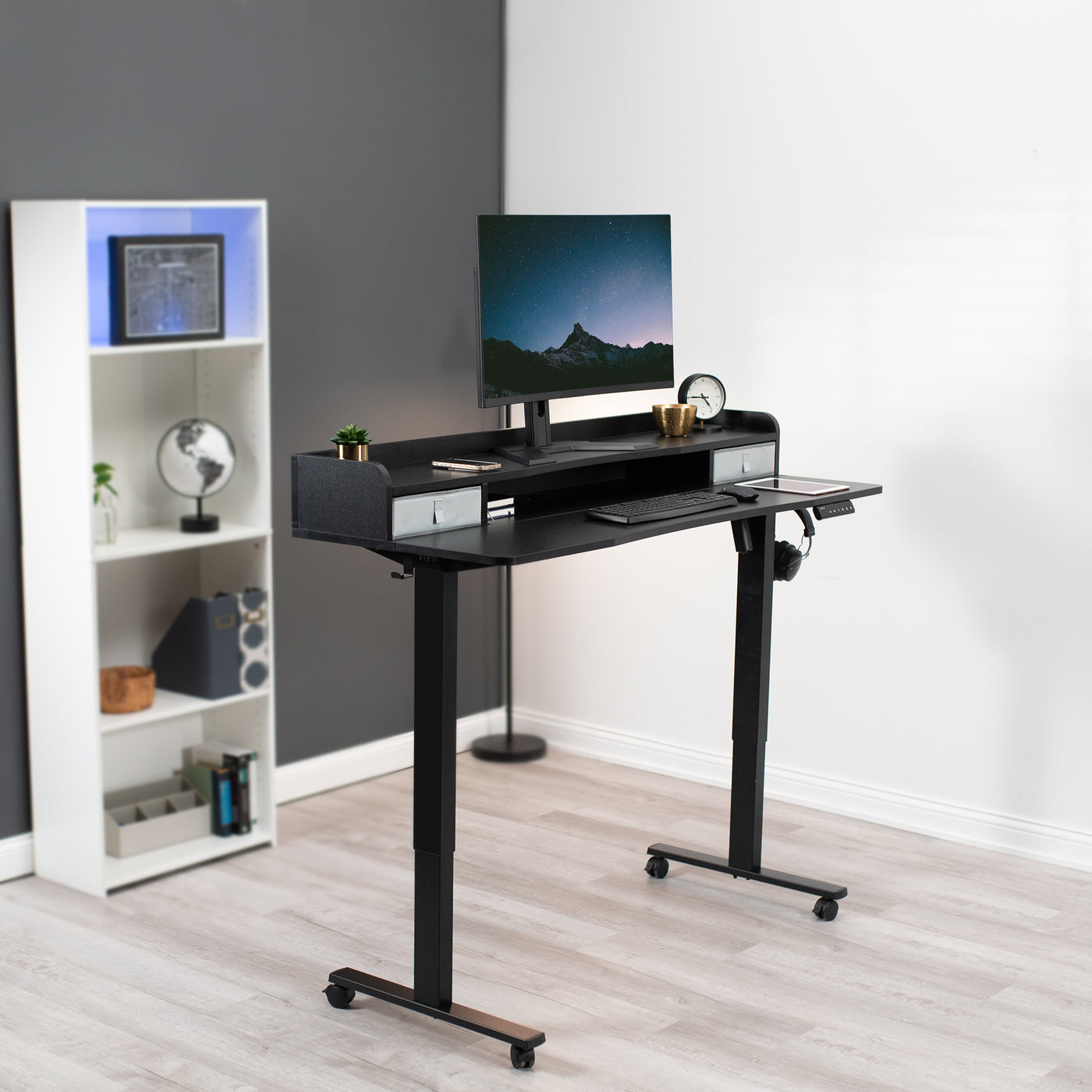 Dual tier height adjustable mobile electric desk with storage drawers.