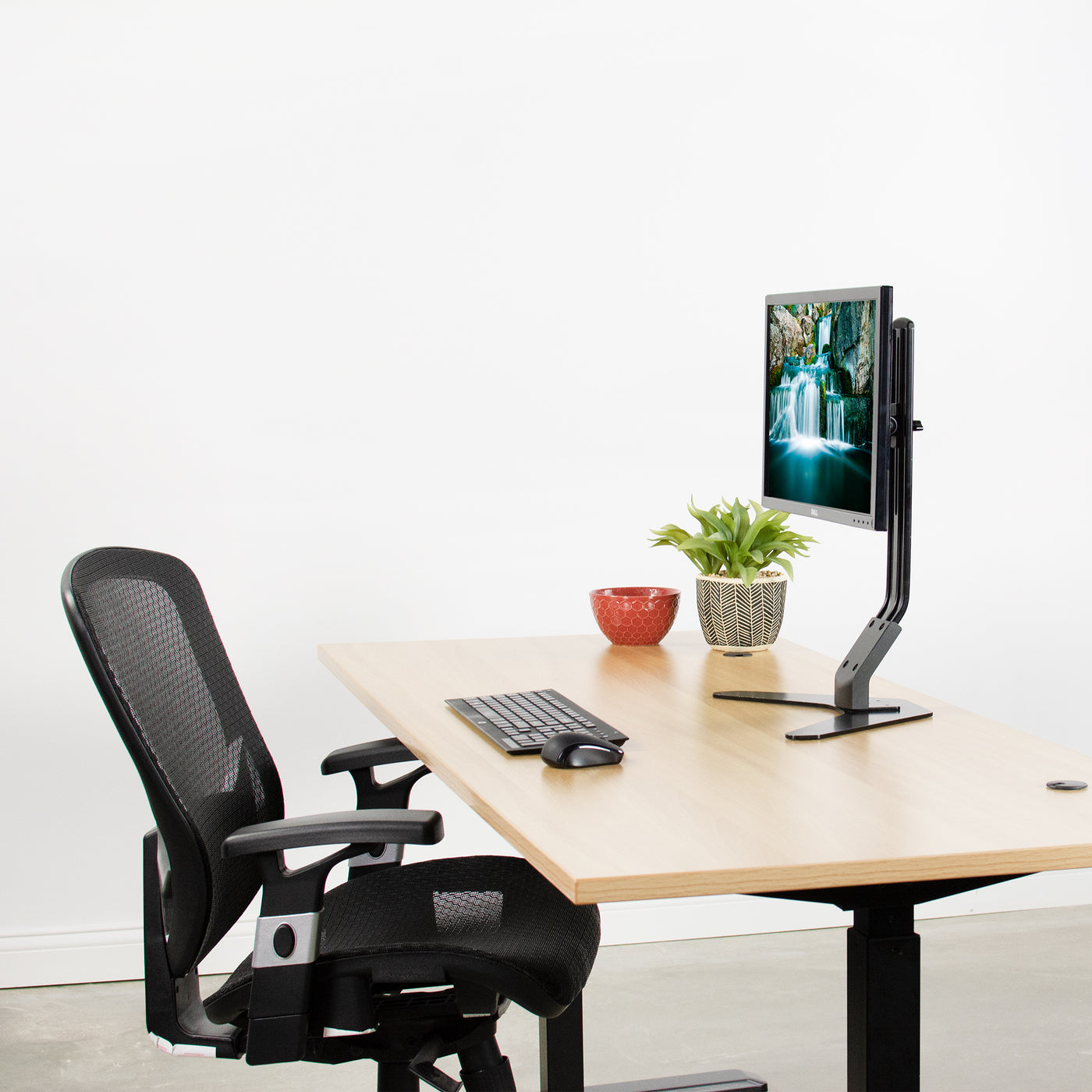 Modern office desk setup with mounted monitor.