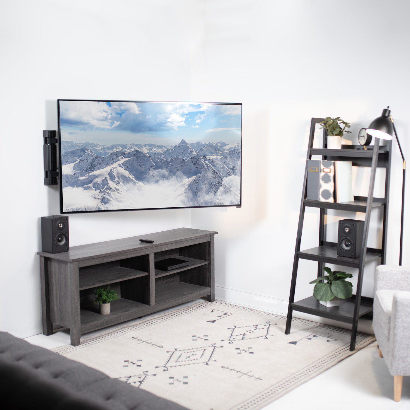 Side extending TV mount supporting large screen TVs in a modern home space.